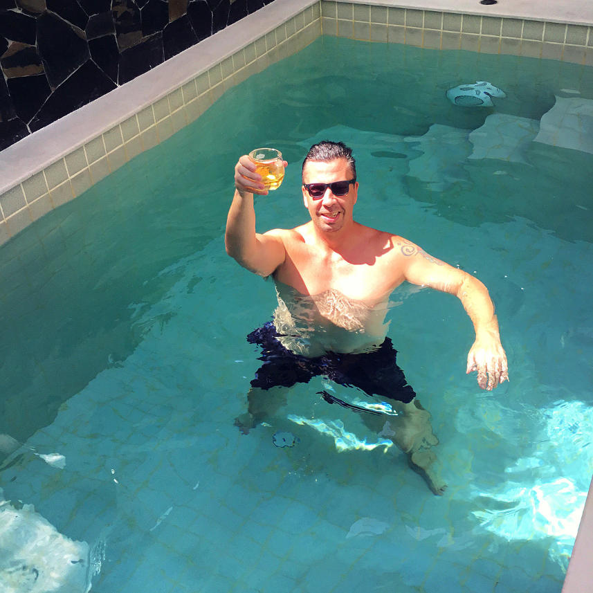 Skål från vår hemmapool Jag tar en drink i vår pool